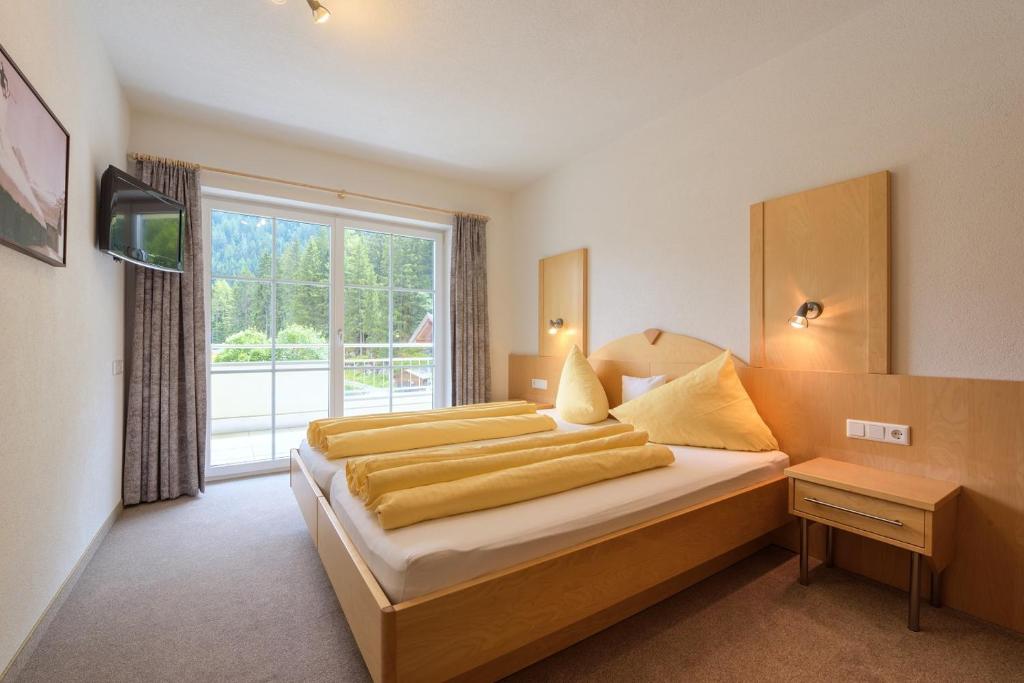 una camera da letto con due letti e una grande finestra di Apart La Vita a Sankt Anton am Arlberg