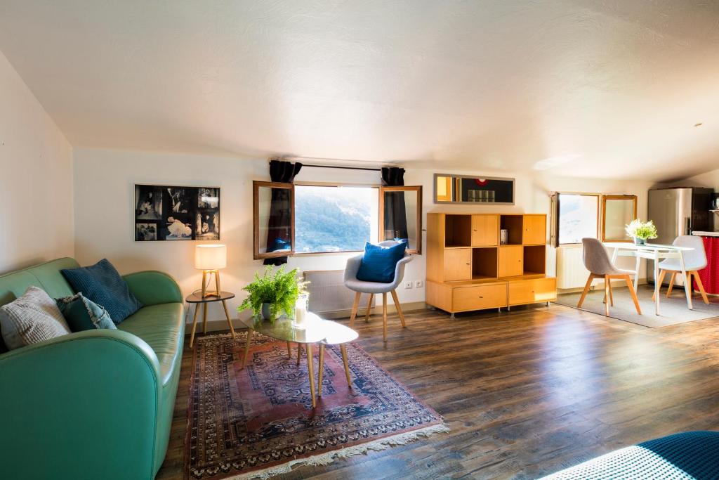 un soggiorno con divano e tavolo di GRAND STUDIO ENTRE MER ET MONTAGNE a Le Bar-sur-Loup
