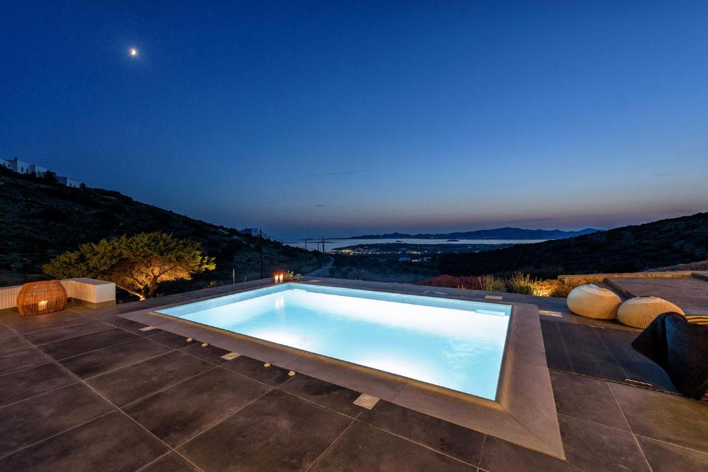 a swimming pool on the roof of a house at night at PAROS VILLA BLUE SENSES in Aliki