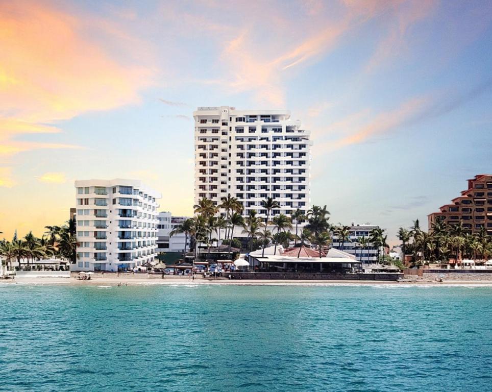 a view of a beach with two tall buildings at The Inn at Mazatlan in Mazatlán