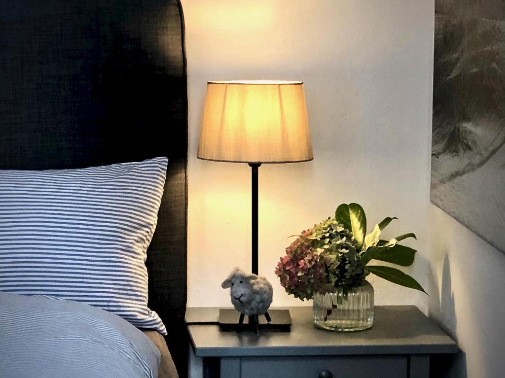 a lamp on a night stand next to a bed at Haus Schlafgemach in Flensburg