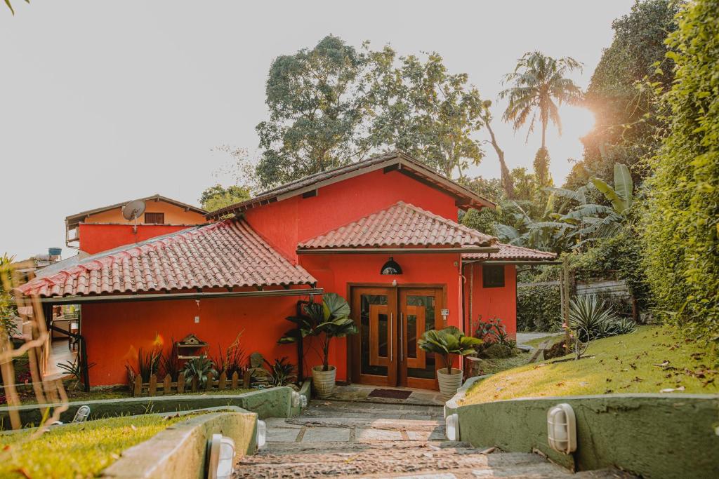 a red house with a pathway in front of it at Hostel Refúgio in Abraão