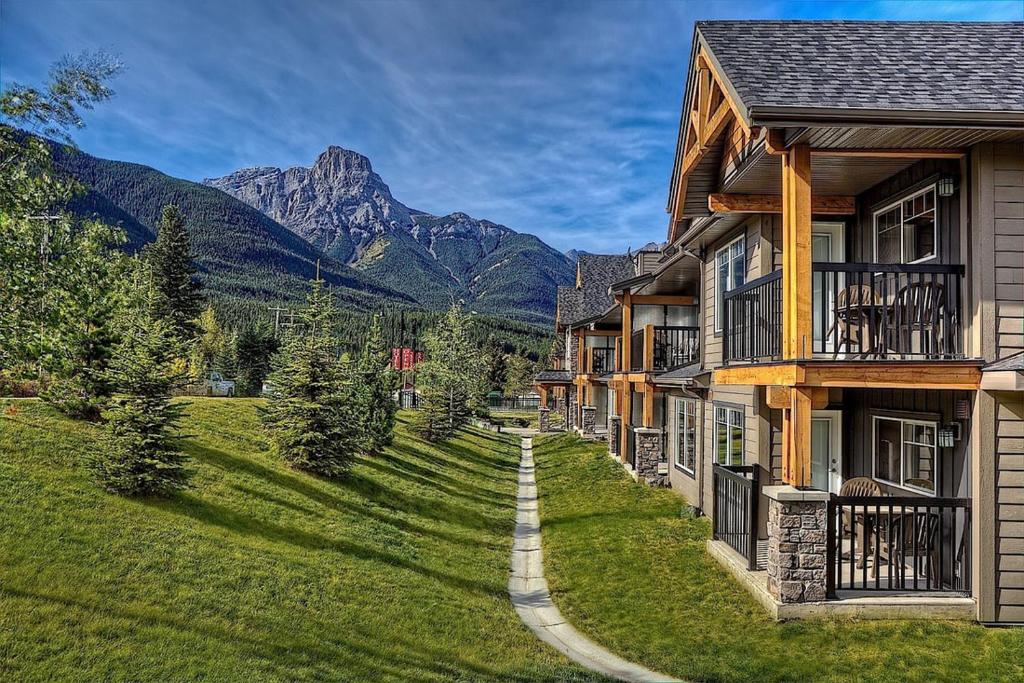 a row of houses with mountains in the background at Copperstone Resort in Dead Man's Flats