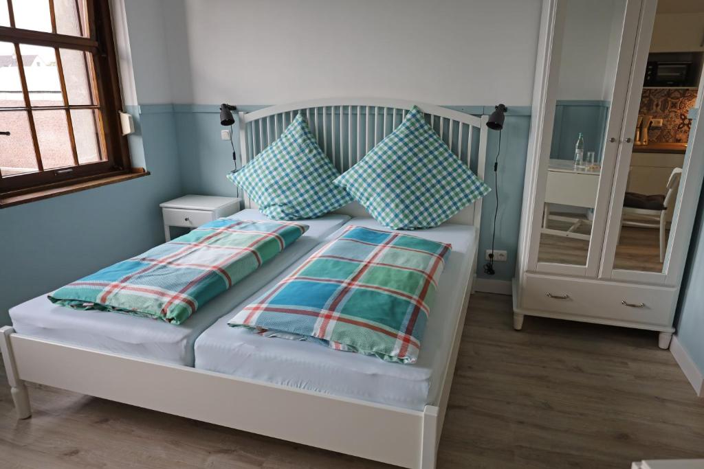 CT-Apartments في كِركِن: سرير أبيض مع وسائد زرقاء في غرفة النوم