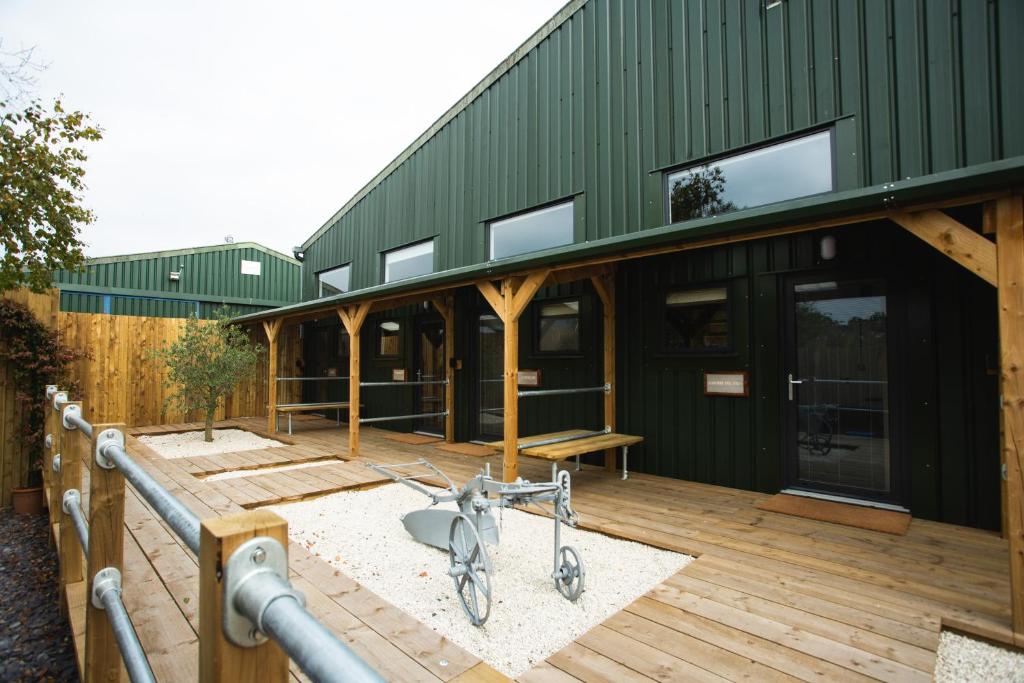 a house with a bike parked on a wooden deck at Owen House Farm in Knutsford