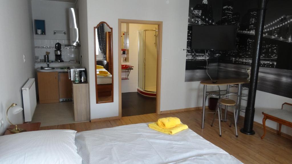 a bedroom with a bed with a yellow towel on it at Pension und Gästehaus Paffrath in Großbrembach