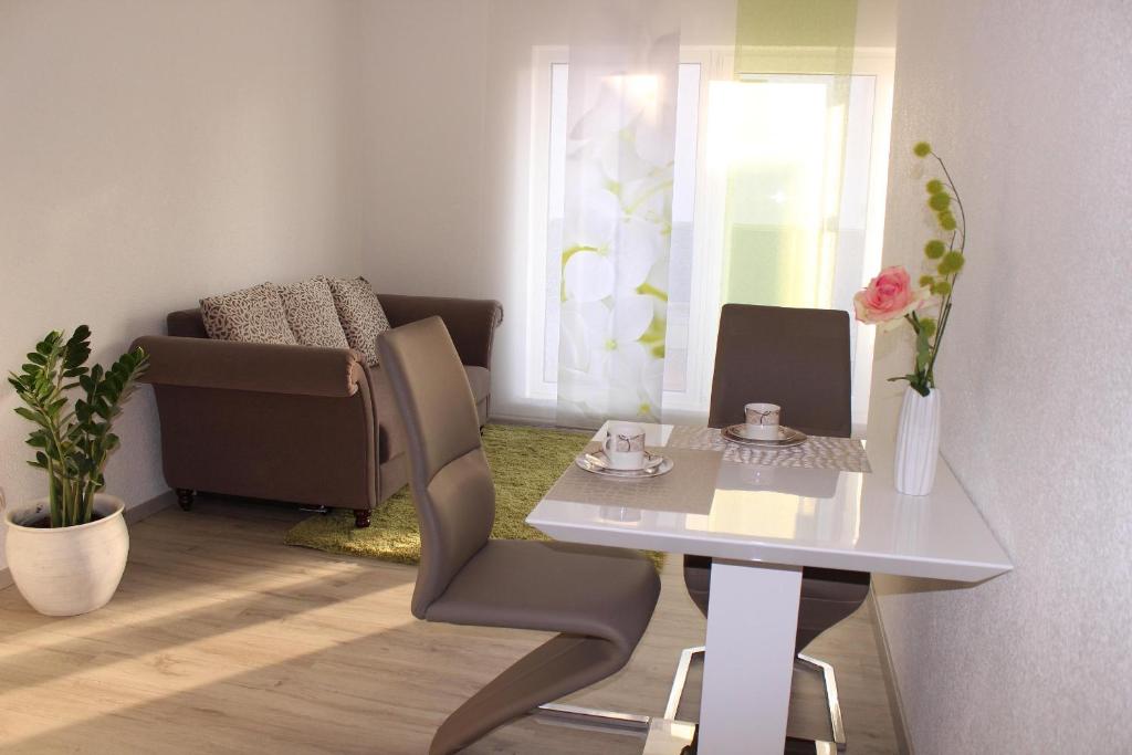 ein kleines Wohnzimmer mit einem Tisch und einem Sofa in der Unterkunft Ferienwohnung Miletta, Zentral Friedrichshafen Bodensee in Friedrichshafen