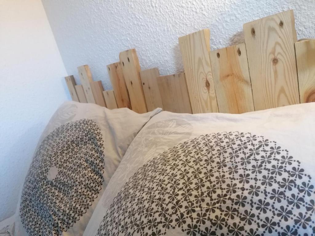 ル・バルカレスにあるstudio cosy avec jardinのベッド(木製のヘッドボード、枕付)