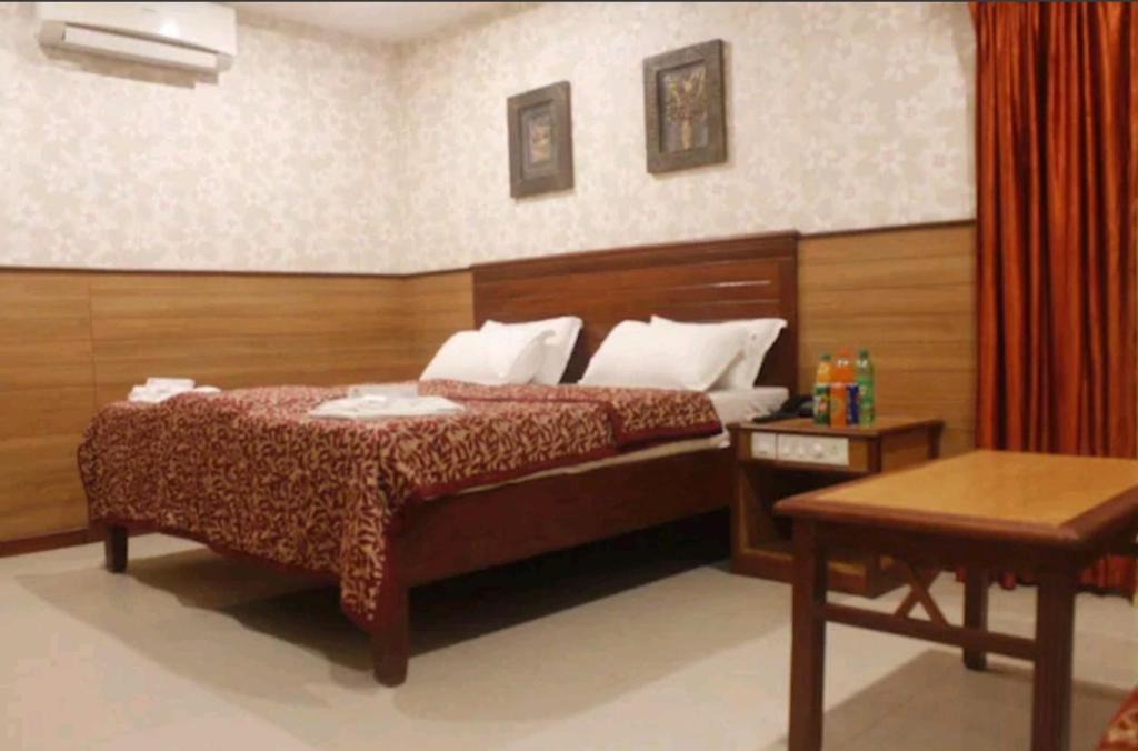 a bedroom with a large bed and a table at Hotel Chitra Park in Thiruchendur