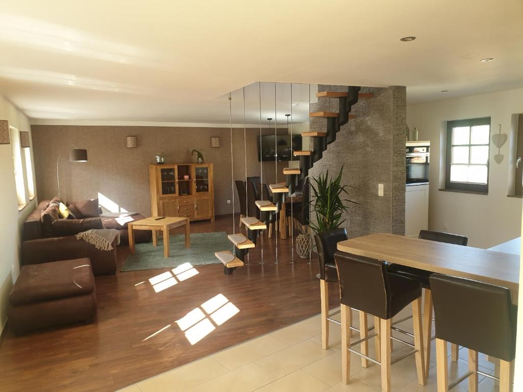 sala de estar con escalera, mesa y sillas en FW Zum Kuckucksnest auf 2 Etagen und 140qm, en Quedlinburg