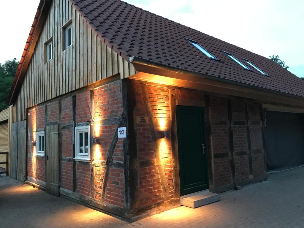 a brick building with a door with lights on it at Gästezimmer Gutshof Bestenbostel Eine Oase der Ruhe in Wedemark