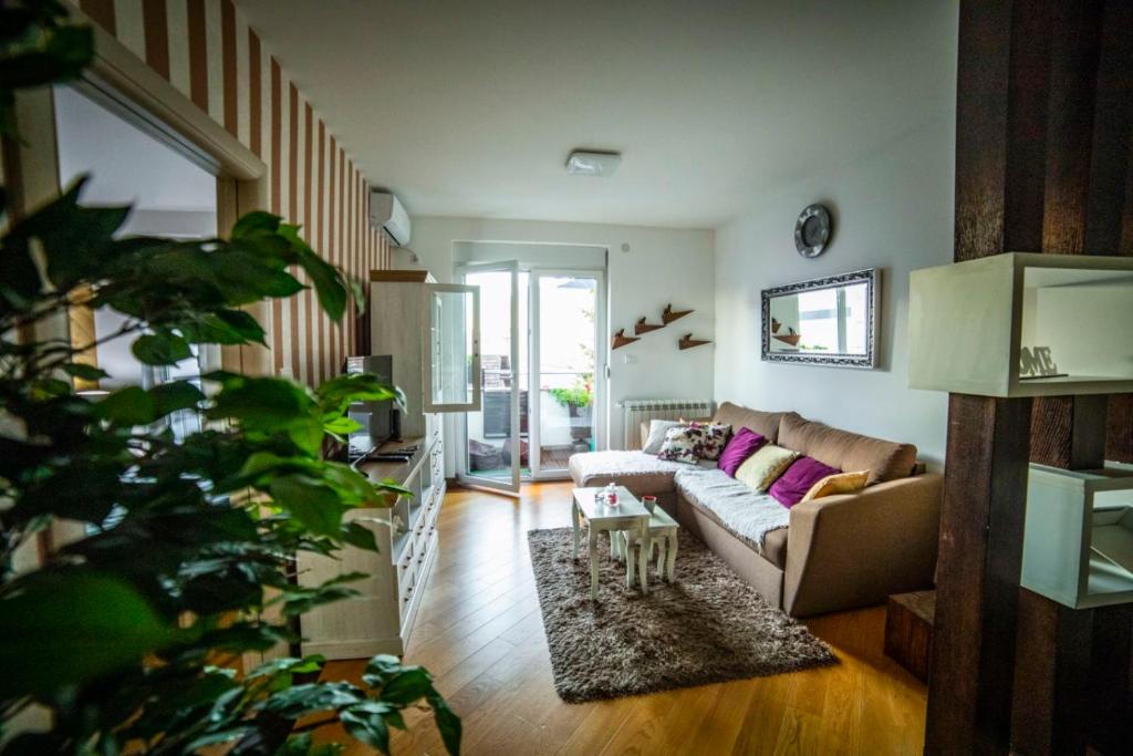 a living room with a couch and a table at Luxury apartmani kg in Kragujevac