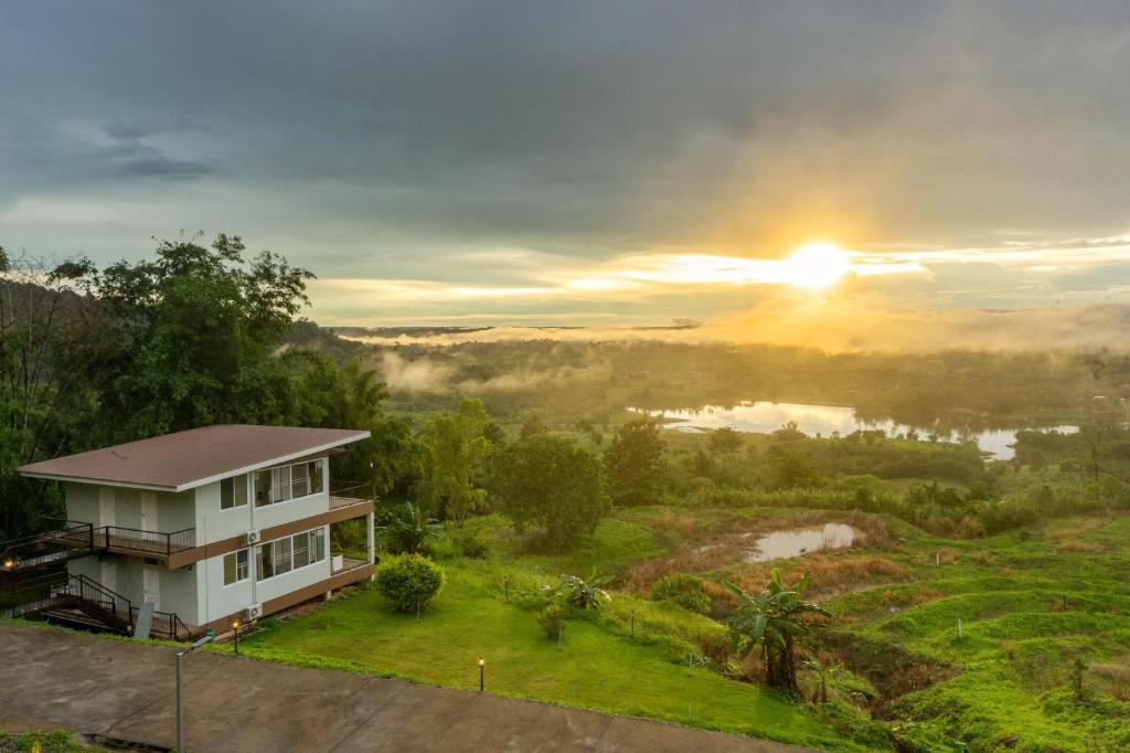 uma casa com o pôr-do-sol ao fundo em The private 2 @ khao kho em Khao Kho