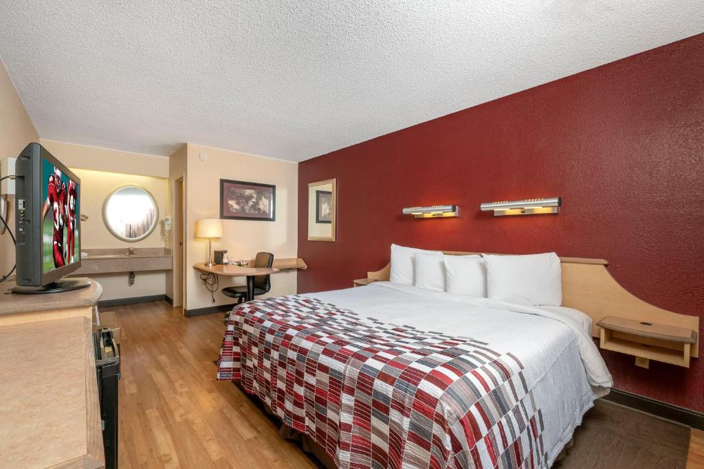 Habitación de hotel con cama y pared roja en Red Roof Inn Philadelphia - Oxford Valley en Langhorne