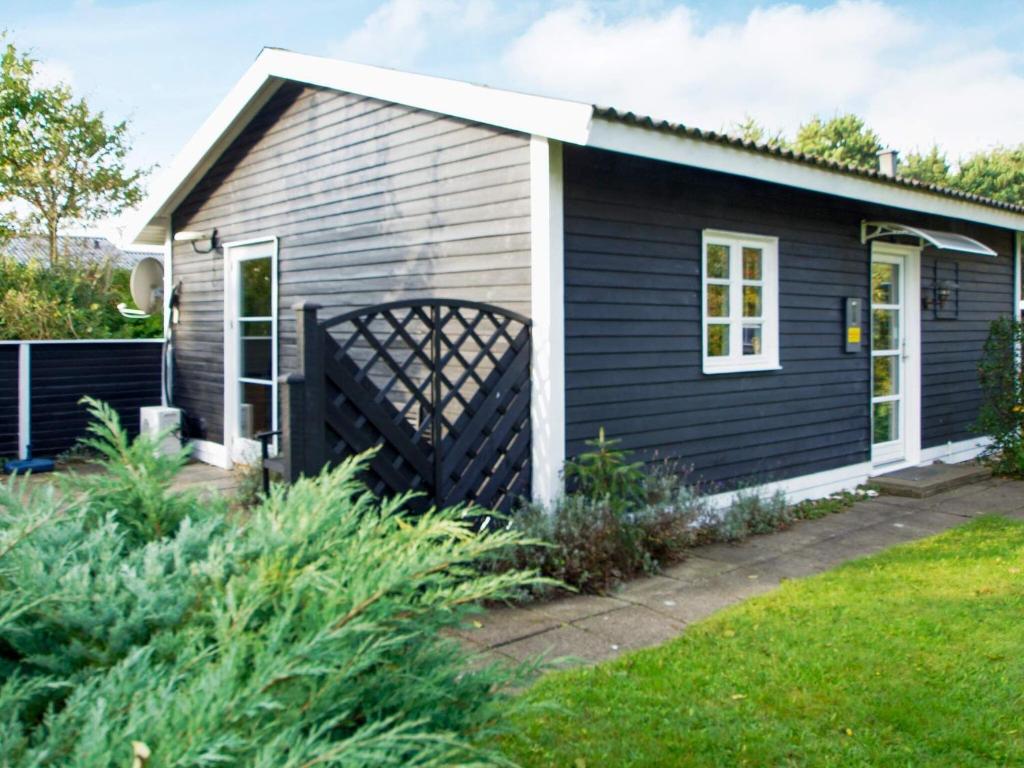 a small house with black siding and a yard at 4 person holiday home in Hemmet in Hemmet