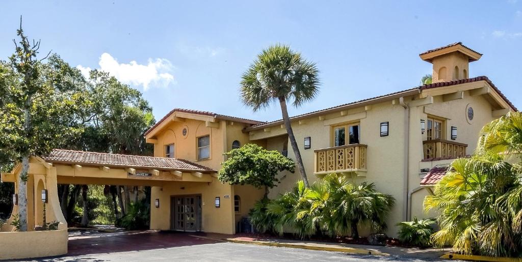 a house with a palm tree in front of it at Red Roof Inn Tampa Bay - St. Petersburg in St Petersburg