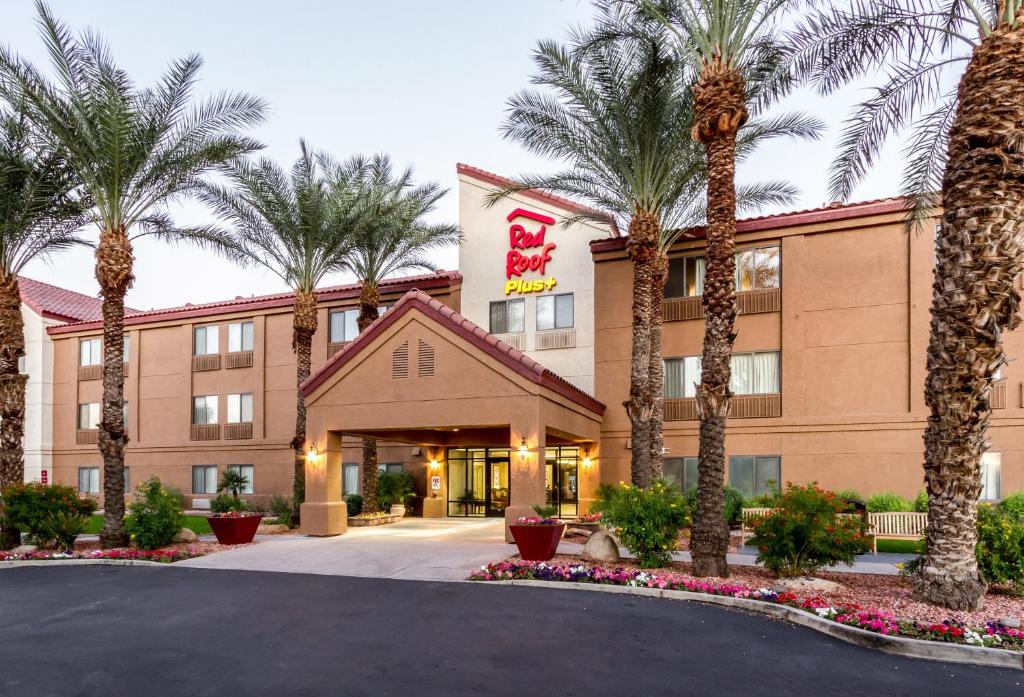 a hotel with palm trees in front of a building at Red Roof Inn PLUS+ Tempe - Phoenix Airport in Tempe