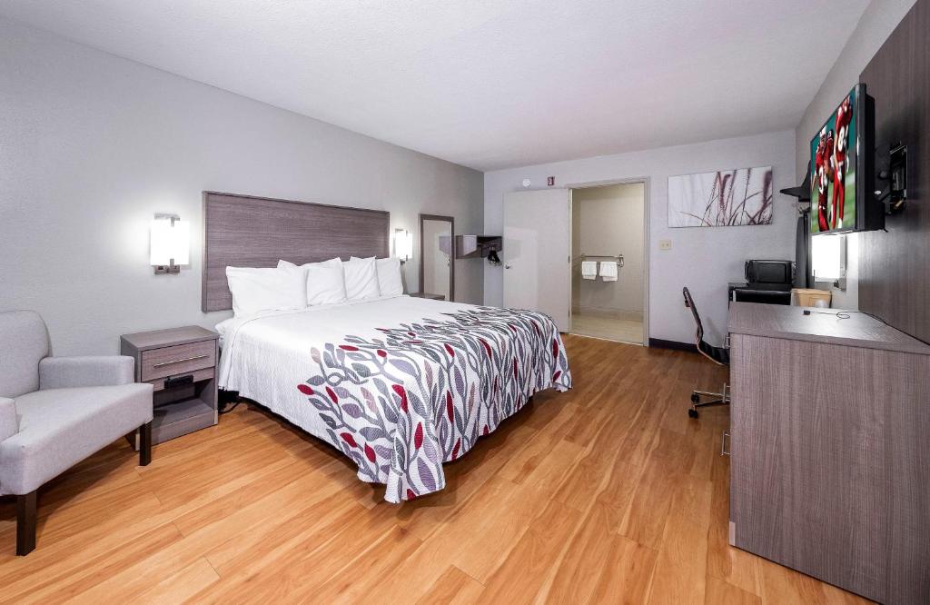 una habitación de hotel con una cama grande y una silla en Red Roof Inn Bay Minette, en Bay Minette