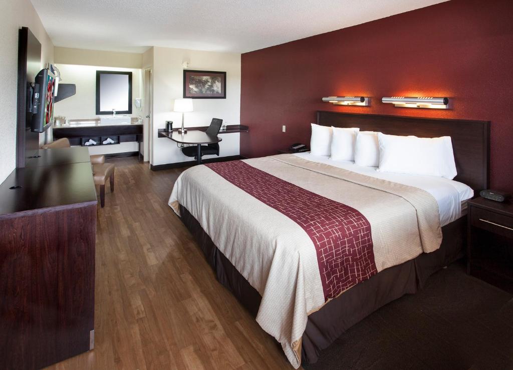 エシントンにあるRed Roof Inn PLUS+ Philadelphia Airportの大きなベッドとデスクが備わるホテルルームです。