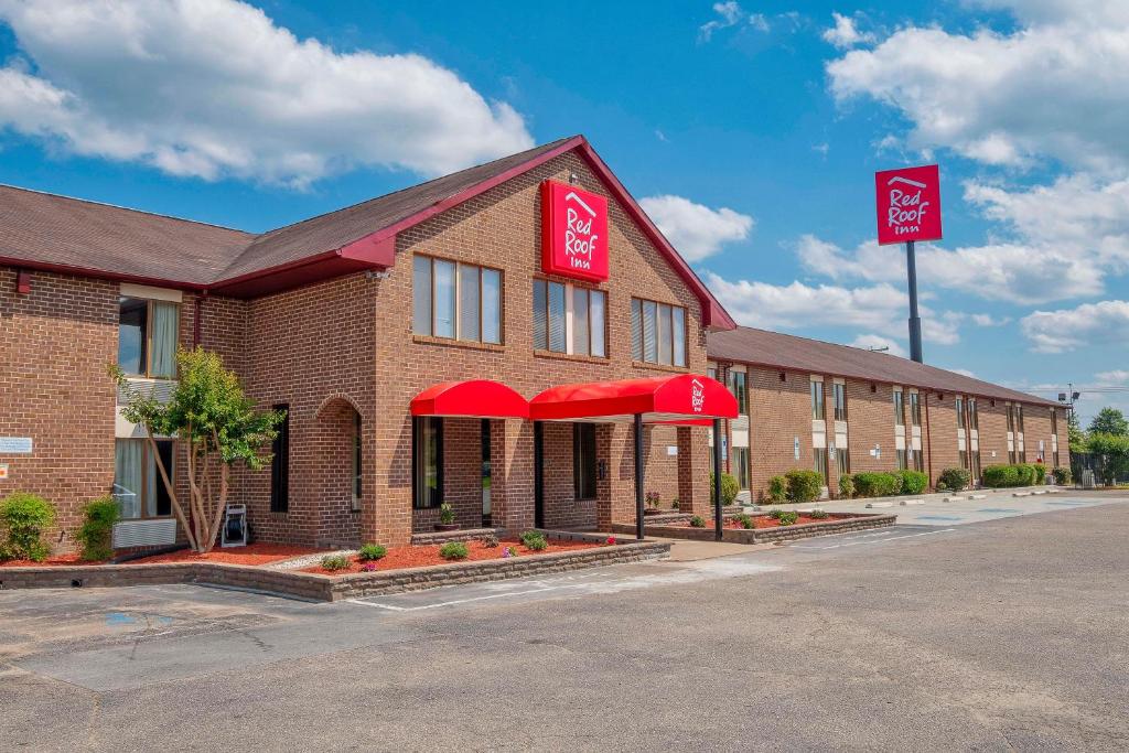 a hotel with red awnings on a brick building at Red Roof Inn Roanoke Rapids in Roanoke Rapids
