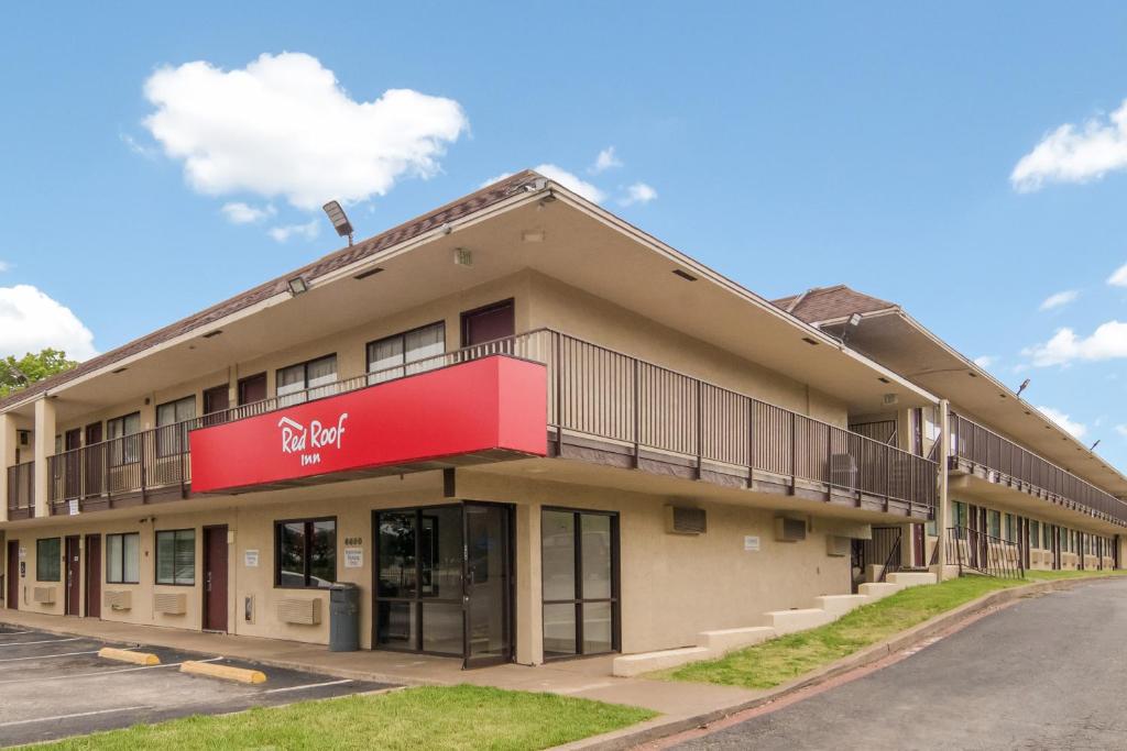 a building with a red sign on the side of it at Red Roof Inn Fort Worth South in Fort Worth