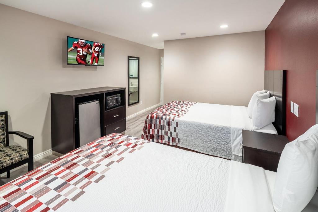une chambre d'hôtel avec deux lits et une chaise dans l'établissement Red Roof Inn St George, UT - Convention Center, à Saint George