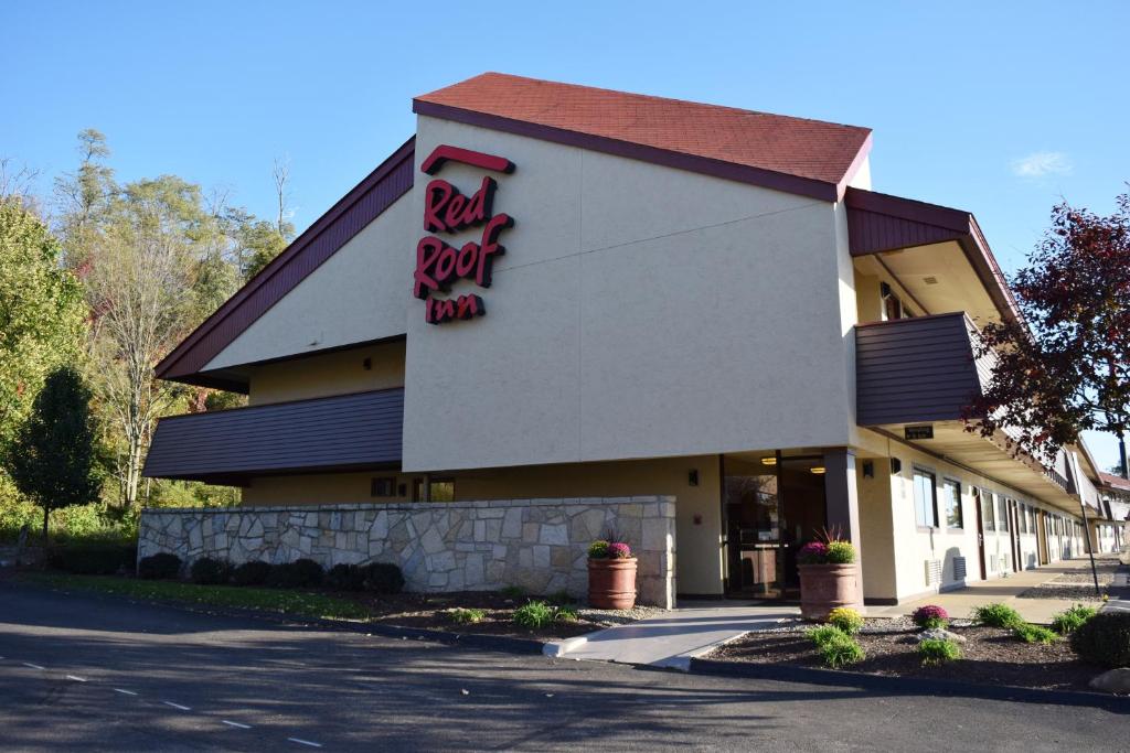 Red Roof Inn St Clairsville - Wheeling West في سانت كليرسفيل: مبنى عليه لوحة نزل على السطح الأحمر