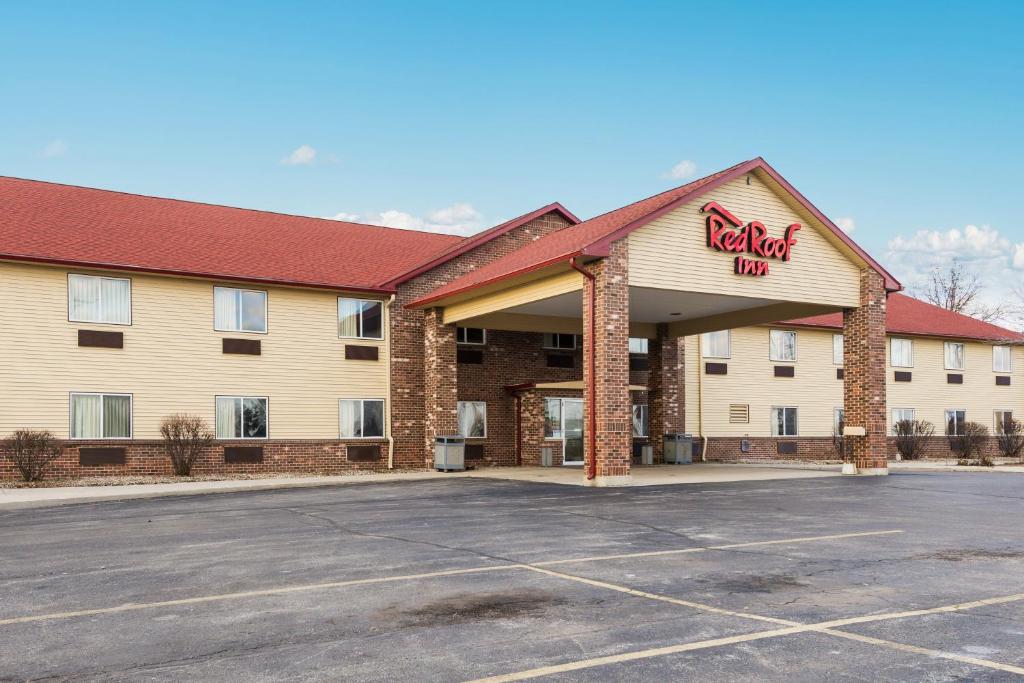 a hotel with a sign on the front of a parking lot at Red Roof Inn Auburn in Auburn