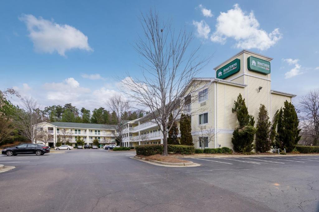 a hotel with a parking lot in front of it at Hometowne Studios by Red Roof Winston-Salem - University Pkwy in Winston-Salem