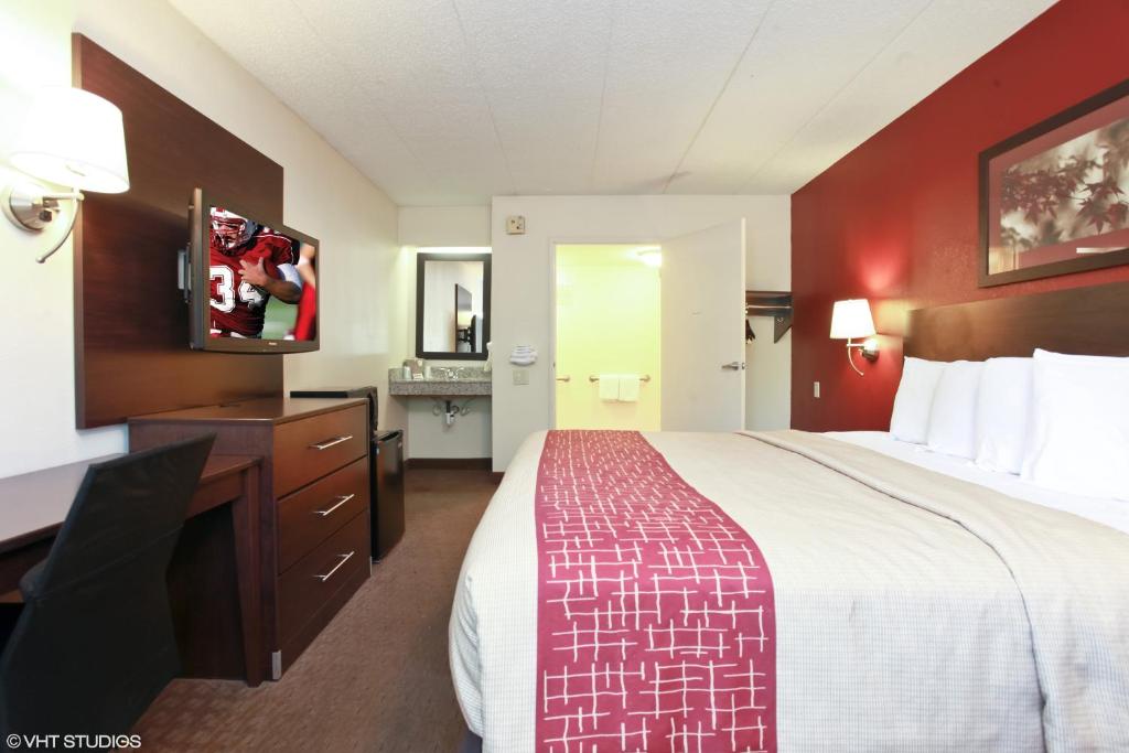 Habitación de hotel con cama grande y TV de pantalla plana. en Red Roof Inn Michigan City, en Michigan City