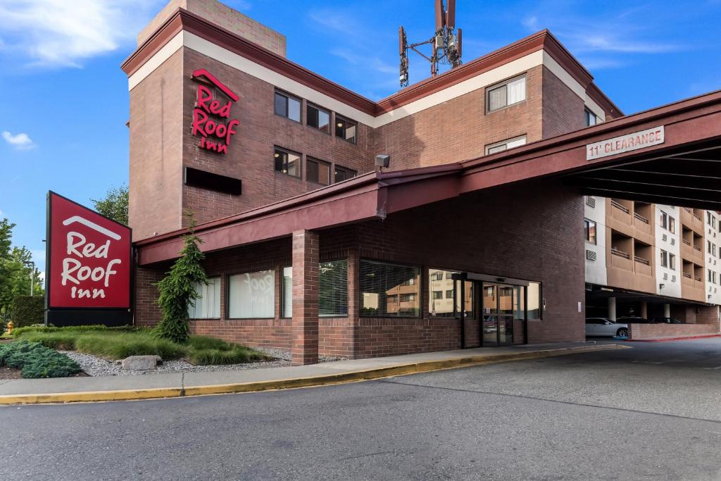 a red roof hotel on the corner of a street at Red Roof Inn Seattle Airport - SEATAC in SeaTac