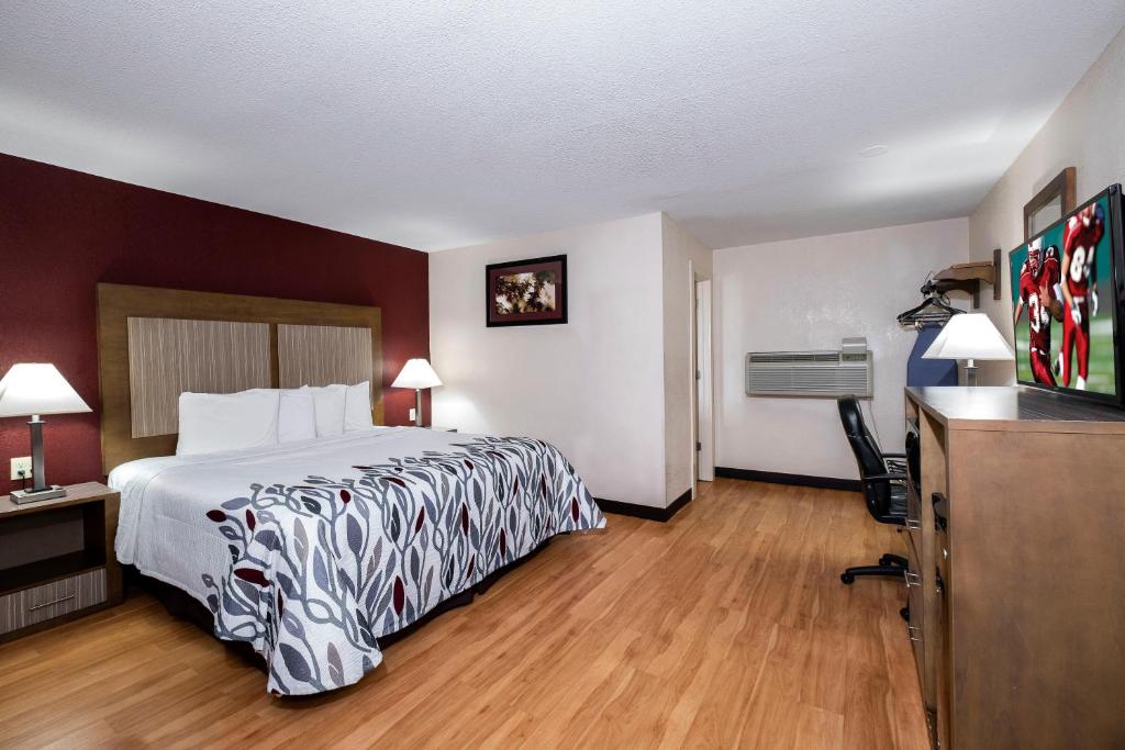 a hotel room with a bed and a desk at Red Roof Inn Neptune - Jersey Shore in Neptune City