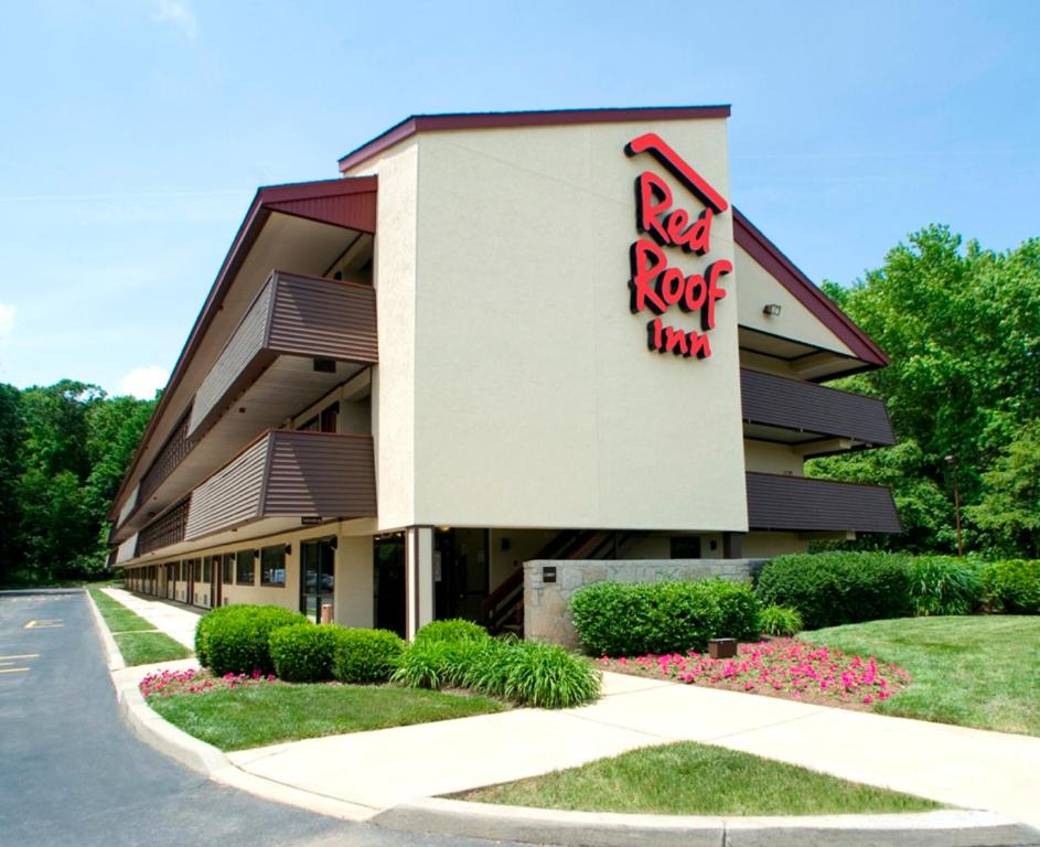 una señal de la posada de roca roja en el lado de un edificio en Red Roof Inn Albany Airport en Albany