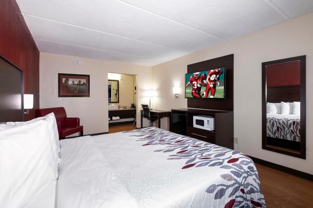 a hotel room with a bed and a living room at Red Roof Inn Kenly - I-95 in Kenly