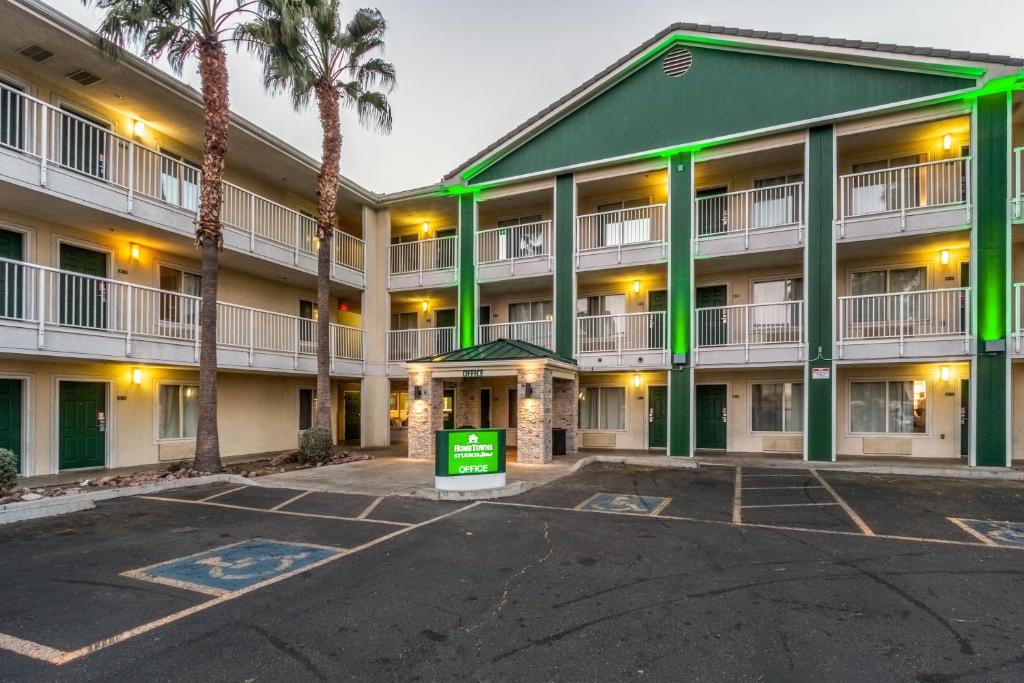 a large apartment building with a parking lot at HomeTowne Studios by Red Roof Phoenix - West in Phoenix