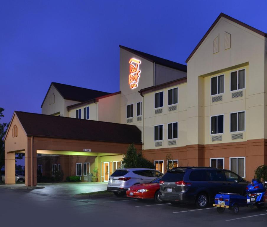 a hotel with cars parked in a parking lot at Red Roof Inn Clyde in Clyde