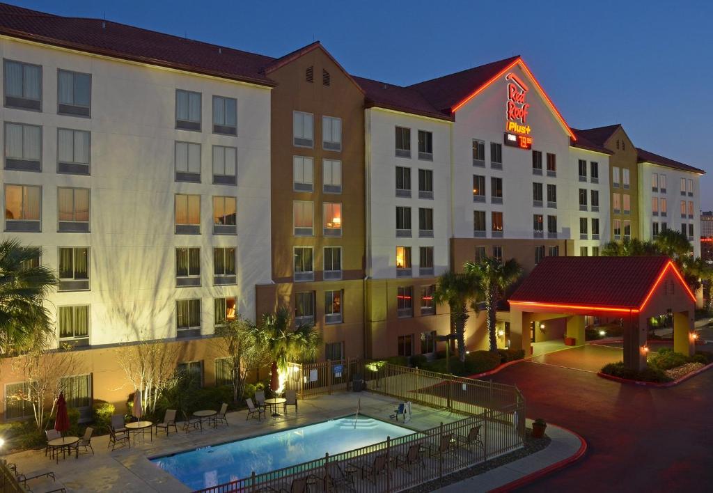 a view of a hotel with a pool and tables at Red Roof Inn PLUS+ San Antonio Downtown - Riverwalk in San Antonio