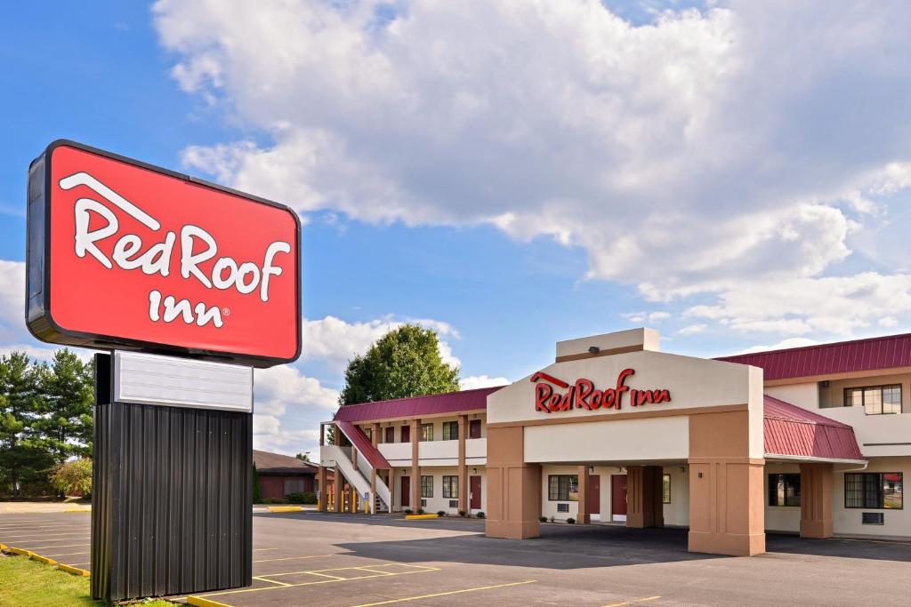 a red krispy kreme sign in front of a motel at Red Roof Inn Marietta in Marietta