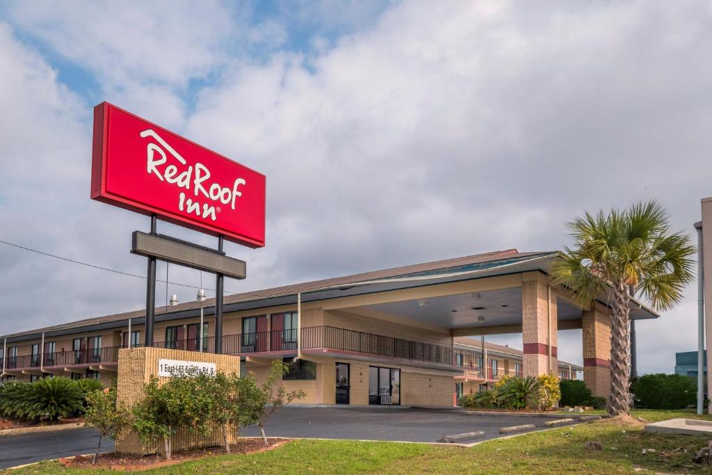 a red rock inn sign in front of a building at Red Roof Inn Mobile - Midtown in Mobile