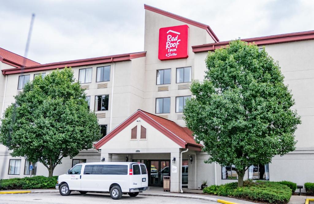 una furgoneta blanca estacionada frente a un hotel en Red Roof Inn & Suites Indianapolis Airport en Indianápolis