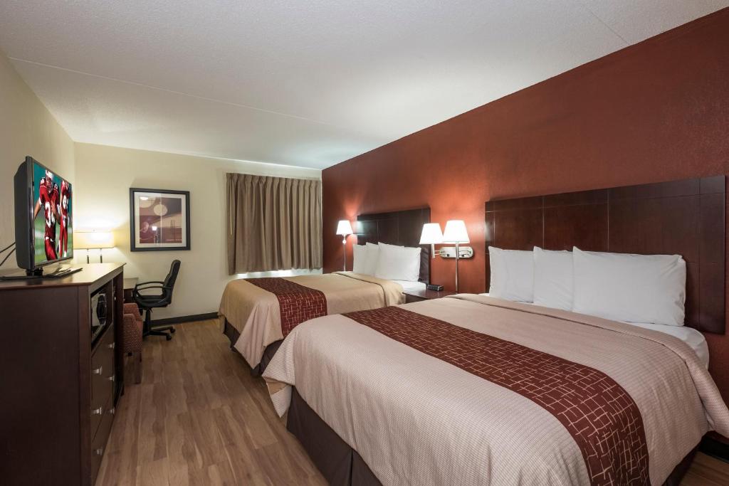 a hotel room with two beds and a television at Red Roof Inn & Suites Cincinnati North-Mason in Mason