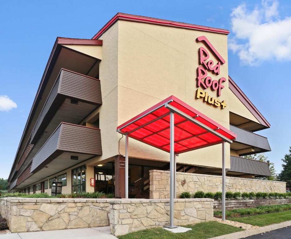 a building with a red sign in front of it at Red Roof Inn PLUS+ Baltimore North - Timonium in Timonium