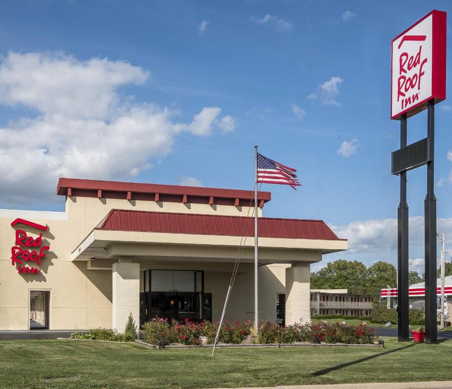 a fast food restaurant with an american flag in front of it at Red Roof Inn Bloomington - Normal/University in Bloomington