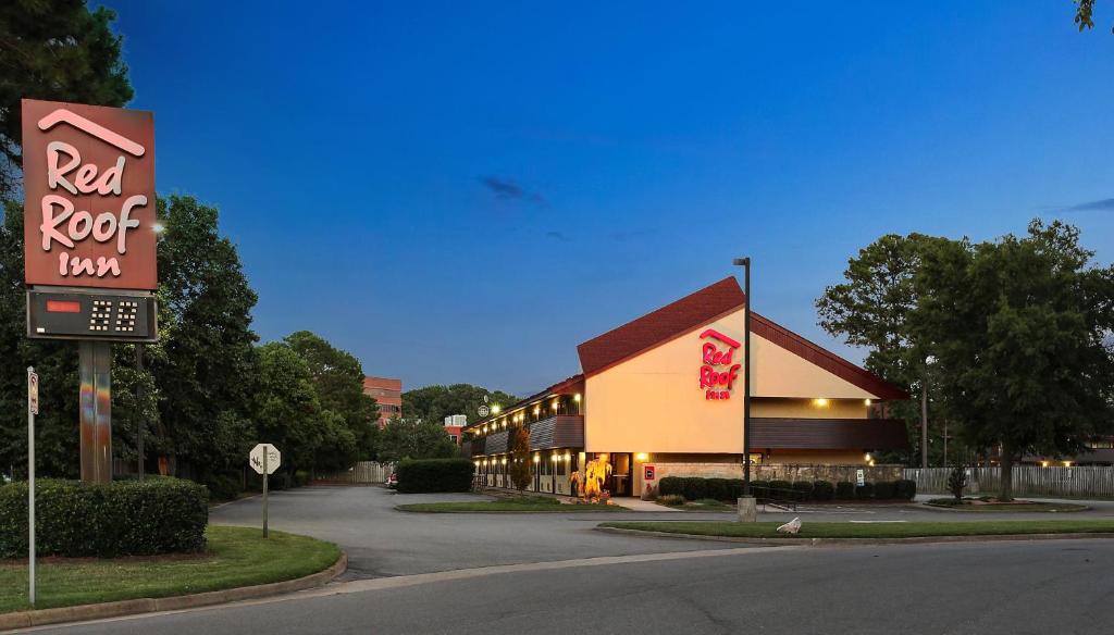 a building with a red rock inn sign next to a street at Red Roof Inn Virginia Beach in Virginia Beach