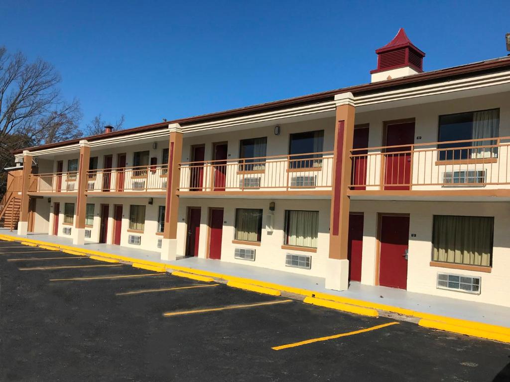 a large white building with a parking lot at Red Roof Inn Memphis - Airport in Memphis