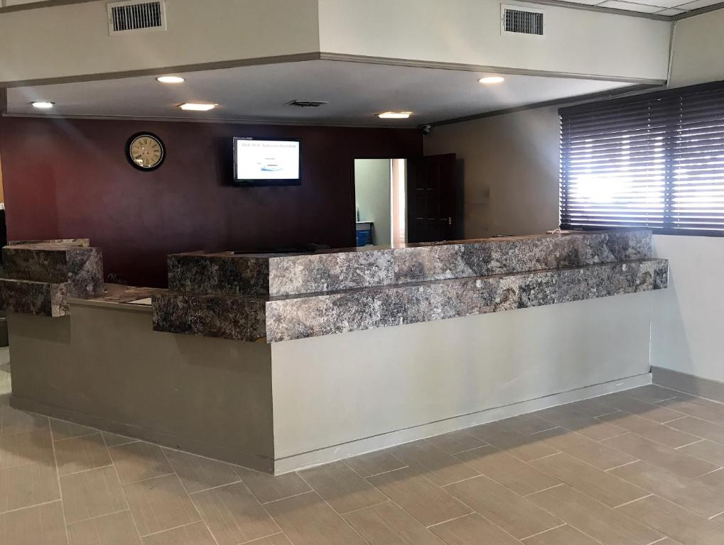 a lobby with a counter with a clock on the wall at Red Roof Inn & Suites San Angelo in San Angelo