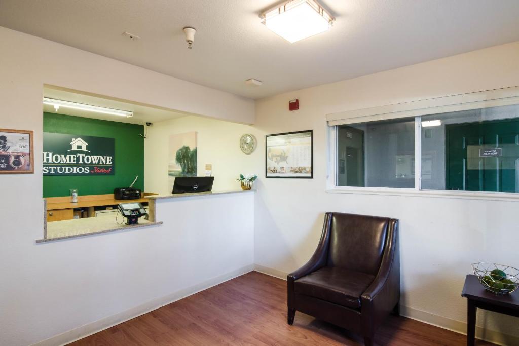 a waiting room with a chair and a counter at HomeTowne Studios by Red Roof Denver - Thornton in Thornton