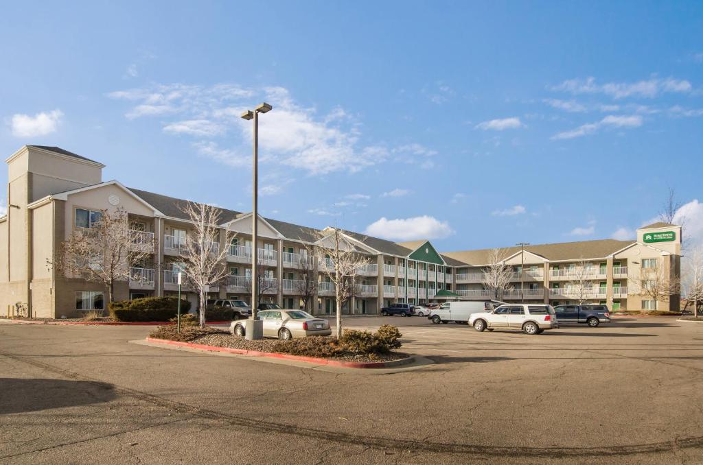 a parking lot with cars parked in front of a building at HomeTowne Studios by Red Roof Denver - Airport/Aurora in Aurora