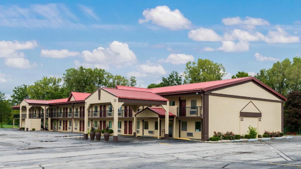 una fila de edificios con techos rojos en un estacionamiento en Red Roof Inn Marion, IN, en Marion