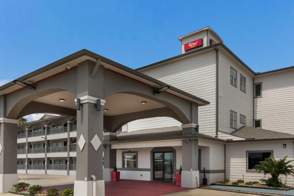 Red Roof Inn PLUS + Galveston - Beachfront في جالفيستون: مبنى كبير مع ساعة حمراء في الأعلى